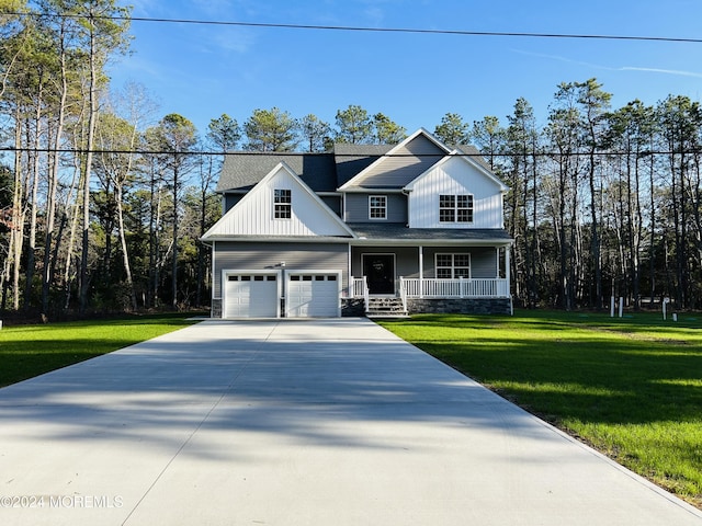 view of front of house featuring a garage, a front yard, and a porch