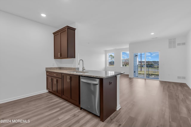 kitchen featuring sink, light wood-type flooring, stainless steel dishwasher, kitchen peninsula, and stone counters