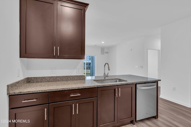 kitchen featuring light hardwood / wood-style floors, dishwasher, sink, and light stone countertops