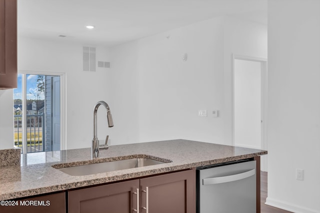 kitchen featuring light stone counters, sink, dark wood-type flooring, and stainless steel dishwasher