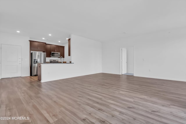 unfurnished living room with sink and light hardwood / wood-style flooring