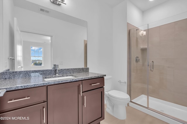 bathroom with vanity, toilet, and a shower with shower door