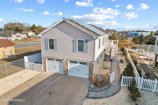 view of side of property with a garage and solar panels