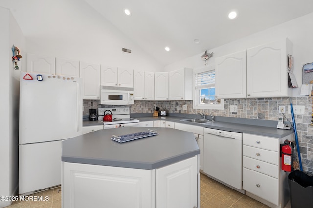 kitchen with white appliances, a kitchen island, and white cabinets