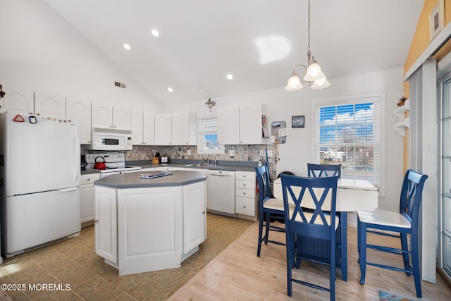 kitchen featuring a kitchen island, decorative light fixtures, white cabinets, decorative backsplash, and white appliances