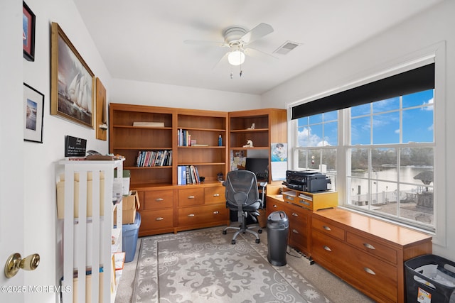 carpeted office featuring ceiling fan