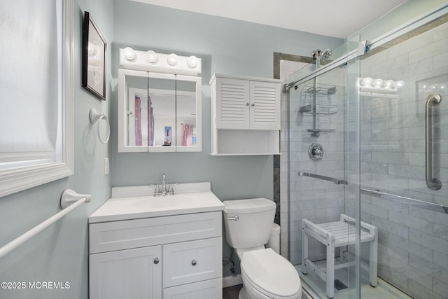 bathroom featuring vanity, an enclosed shower, and toilet