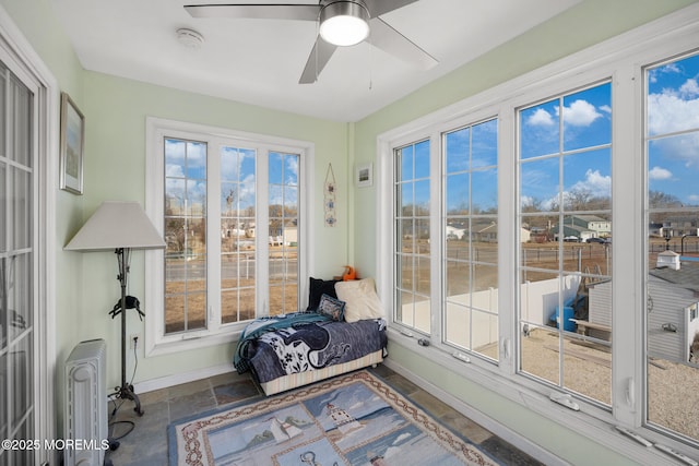 sunroom featuring radiator heating unit and ceiling fan