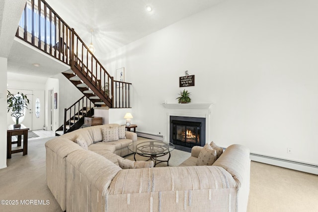 carpeted living room featuring a towering ceiling and baseboard heating