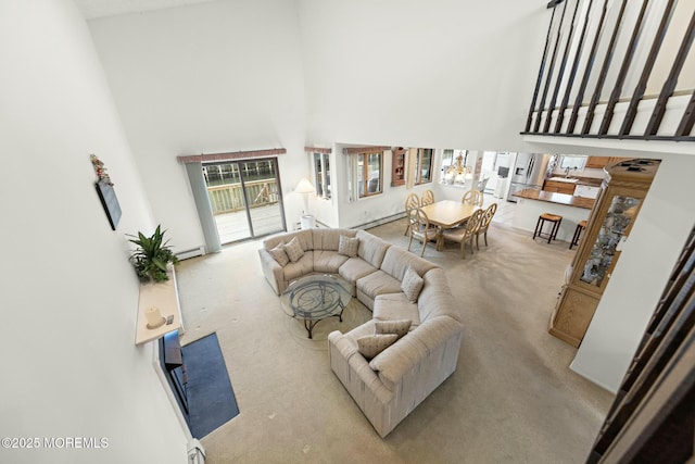 living room featuring a towering ceiling and a baseboard heating unit