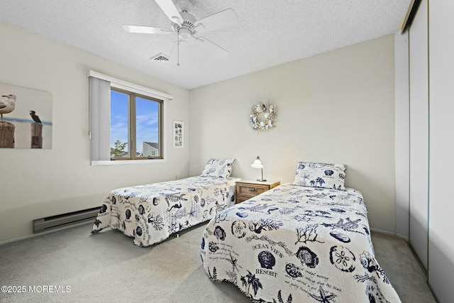 bedroom featuring ceiling fan, a textured ceiling, baseboard heating, and a closet