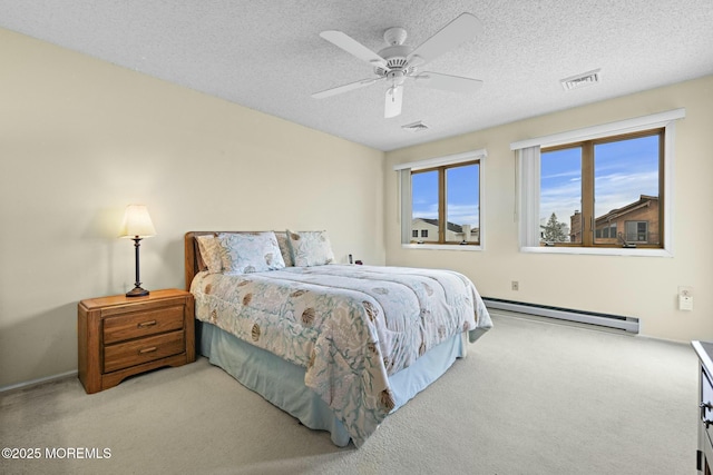 carpeted bedroom featuring baseboard heating, ceiling fan, and a textured ceiling