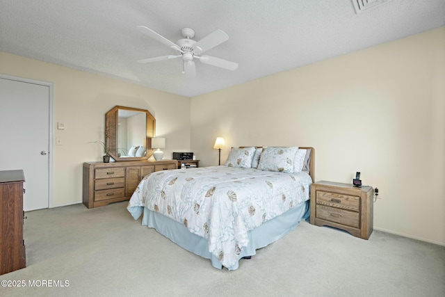 bedroom featuring ceiling fan, light carpet, and a textured ceiling