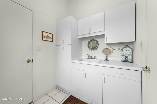 kitchen with light tile patterned flooring, sink, and white cabinets