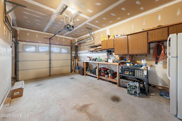 garage with white refrigerator and a garage door opener