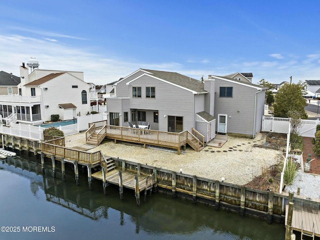 back of property featuring a deck with water view and a shed