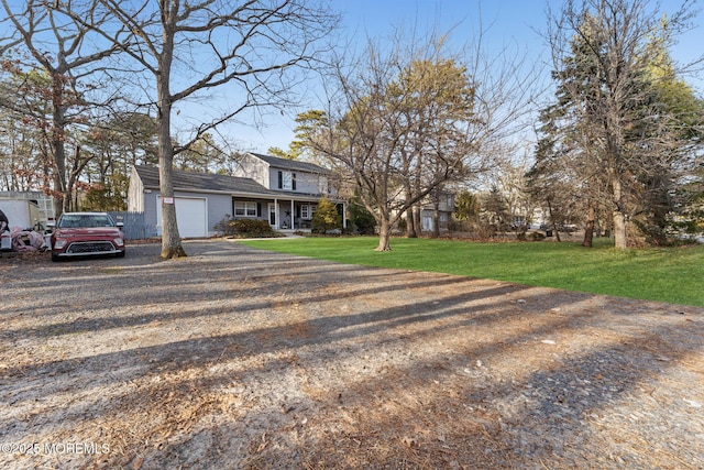 view of front of home featuring a porch, a garage, and a front lawn