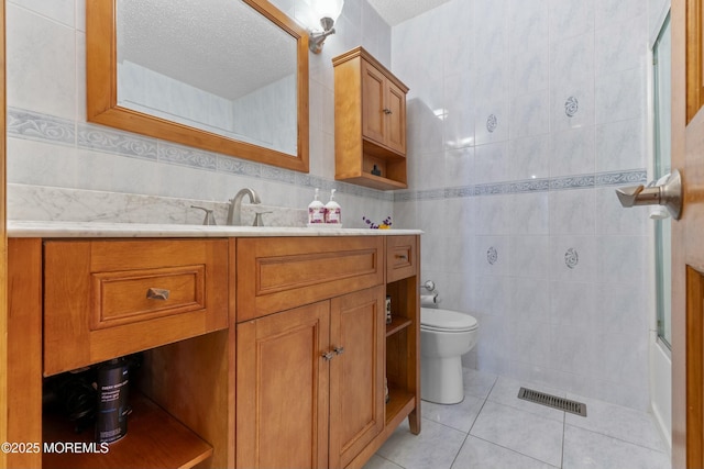 18 Tall Oaks Ct, Old Bridge, NJ 08857 - bathroom with tile walls, tile patterned flooring, vanity, toilet, and a textured ceiling