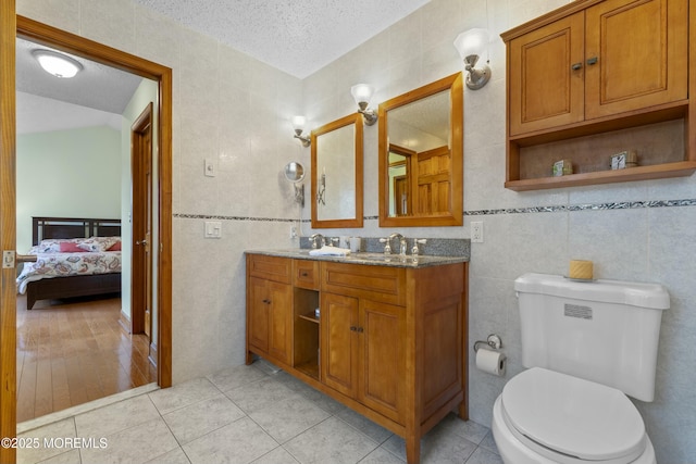 18 Tall Oaks Ct, Old Bridge, NJ 08857 - ensuite bathroom featuring tile walls, a textured ceiling, toilet, tile patterned flooring, and double vanity