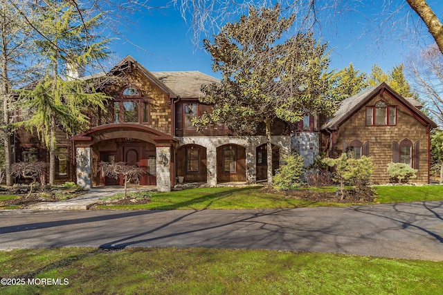 tudor home with a front lawn