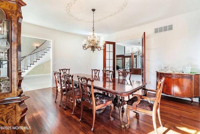 dining room featuring an inviting chandelier and dark wood-type flooring