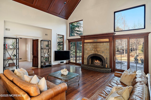 living room featuring dark hardwood / wood-style flooring, a brick fireplace, and high vaulted ceiling