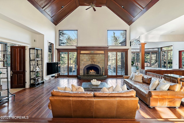 living room with dark wood-type flooring, ceiling fan, high vaulted ceiling, and ornate columns