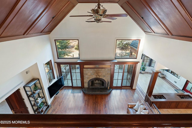 unfurnished living room with ceiling fan, wood-type flooring, and high vaulted ceiling