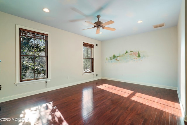 empty room featuring dark wood-type flooring and ceiling fan