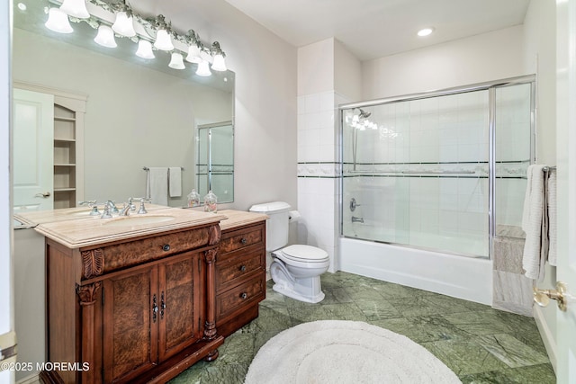 full bathroom with vanity, toilet, and combined bath / shower with glass door