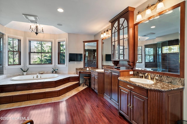 bathroom with vanity, hardwood / wood-style floors, a bathing tub, and an inviting chandelier