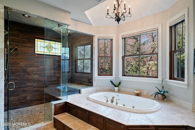 bathroom with independent shower and bath and a chandelier