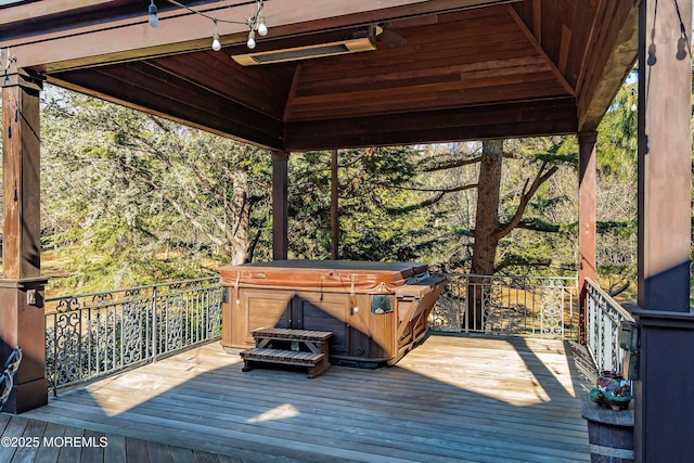 wooden deck featuring a hot tub and a gazebo