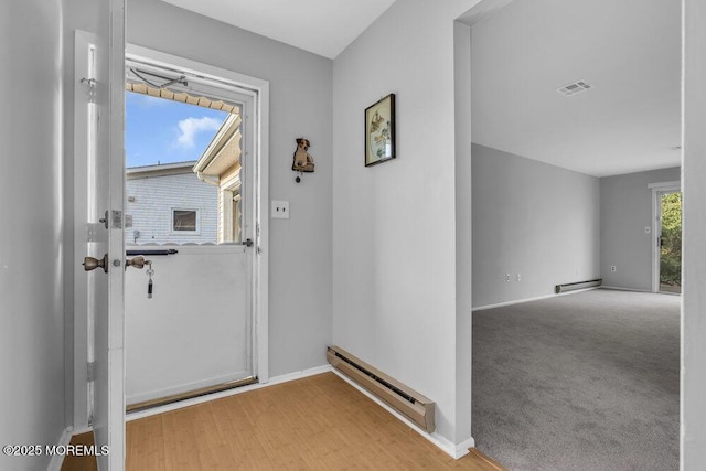 entryway featuring baseboard heating and light carpet