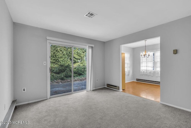 spare room featuring a baseboard heating unit, a chandelier, and carpet flooring