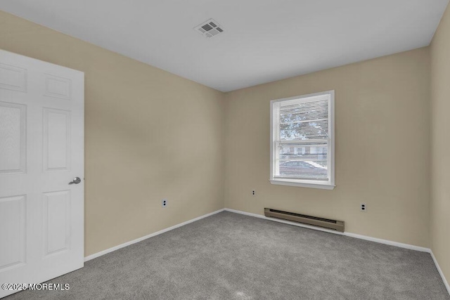 carpeted spare room featuring baseboard heating