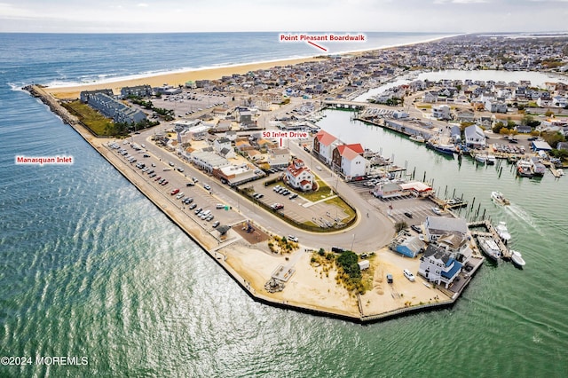 drone / aerial view featuring a water view and a view of the beach