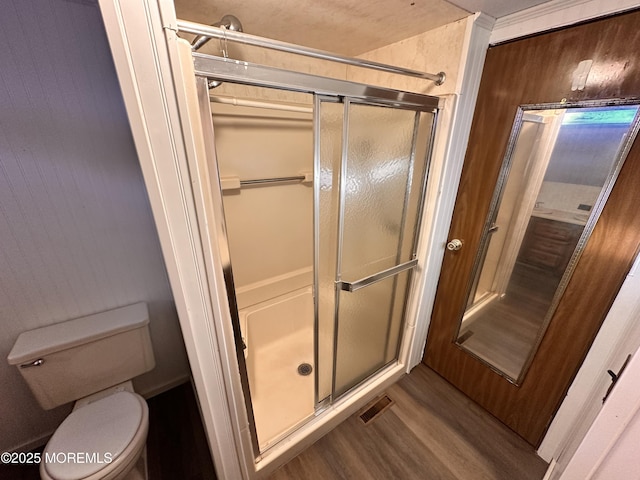 bathroom featuring hardwood / wood-style floors, an enclosed shower, and toilet