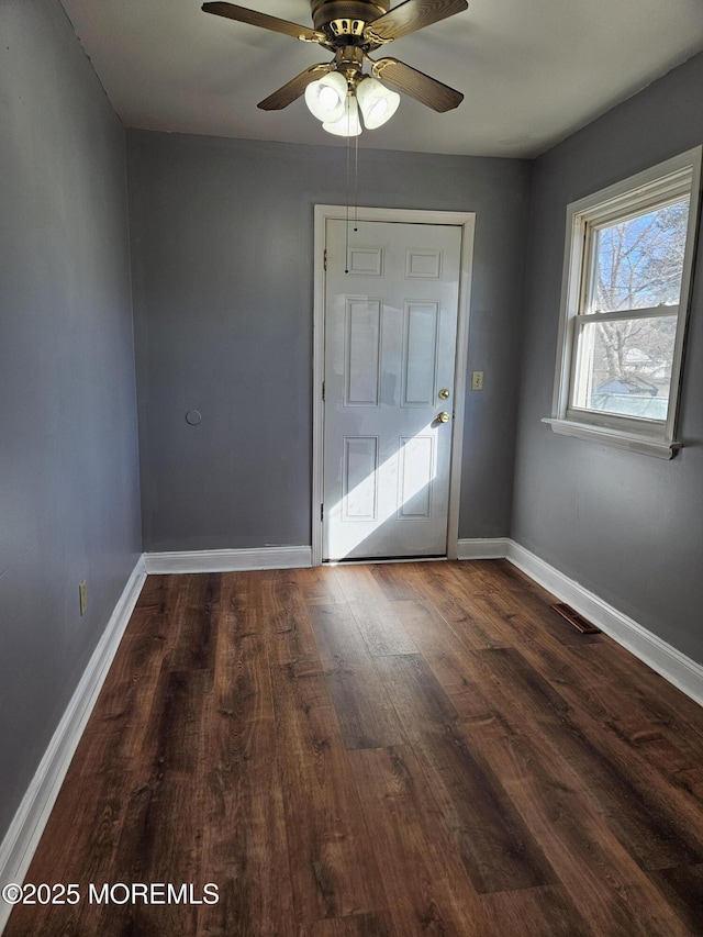 doorway with ceiling fan and dark hardwood / wood-style flooring