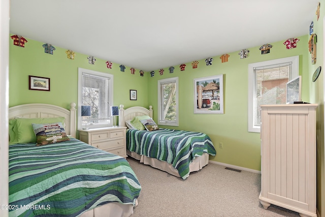 carpeted bedroom featuring multiple windows