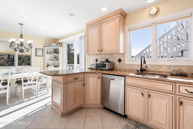 kitchen featuring pendant lighting, sink, backsplash, light tile patterned flooring, and stainless steel dishwasher