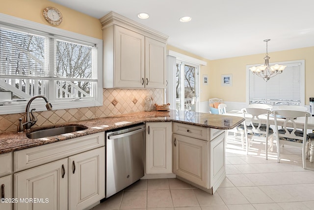 kitchen with sink, dishwasher, kitchen peninsula, pendant lighting, and backsplash