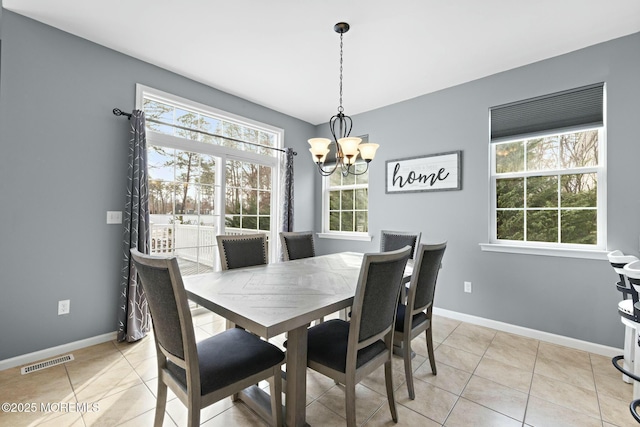 dining space with light tile patterned floors and a chandelier