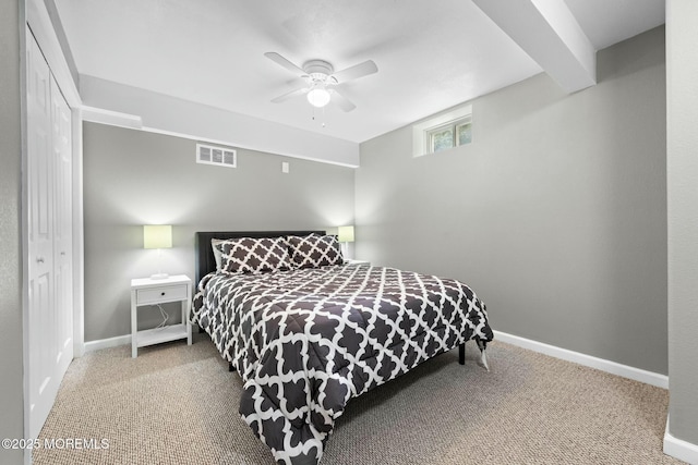 bedroom with ceiling fan, beam ceiling, carpet floors, and a closet