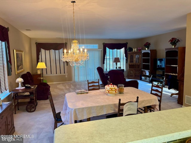 dining area with a chandelier and carpet