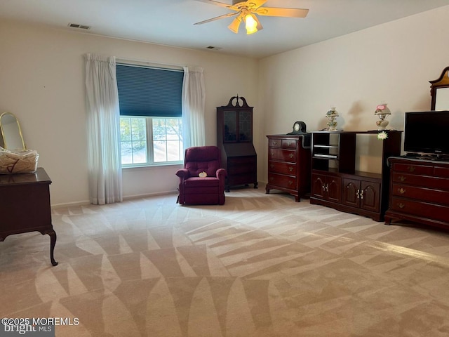 living area with light carpet and ceiling fan