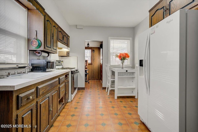 kitchen with sink, white appliances, and light tile patterned floors