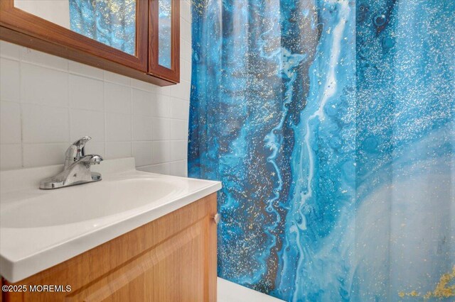 bathroom featuring vanity and backsplash