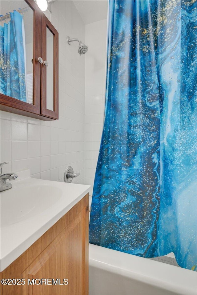 bathroom with vanity, backsplash, and shower / bath combo with shower curtain