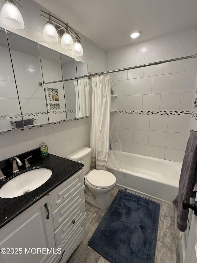 full bathroom with tile walls, vanity, wood-type flooring, shower / bath combination with curtain, and toilet